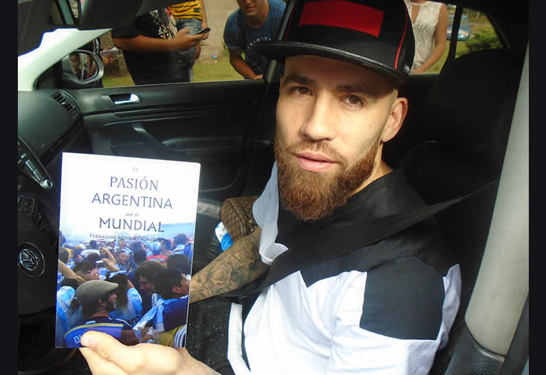 El jugador de fútbol Nicolás Otamendi con el libro La Pasión Argentina por el Mundial